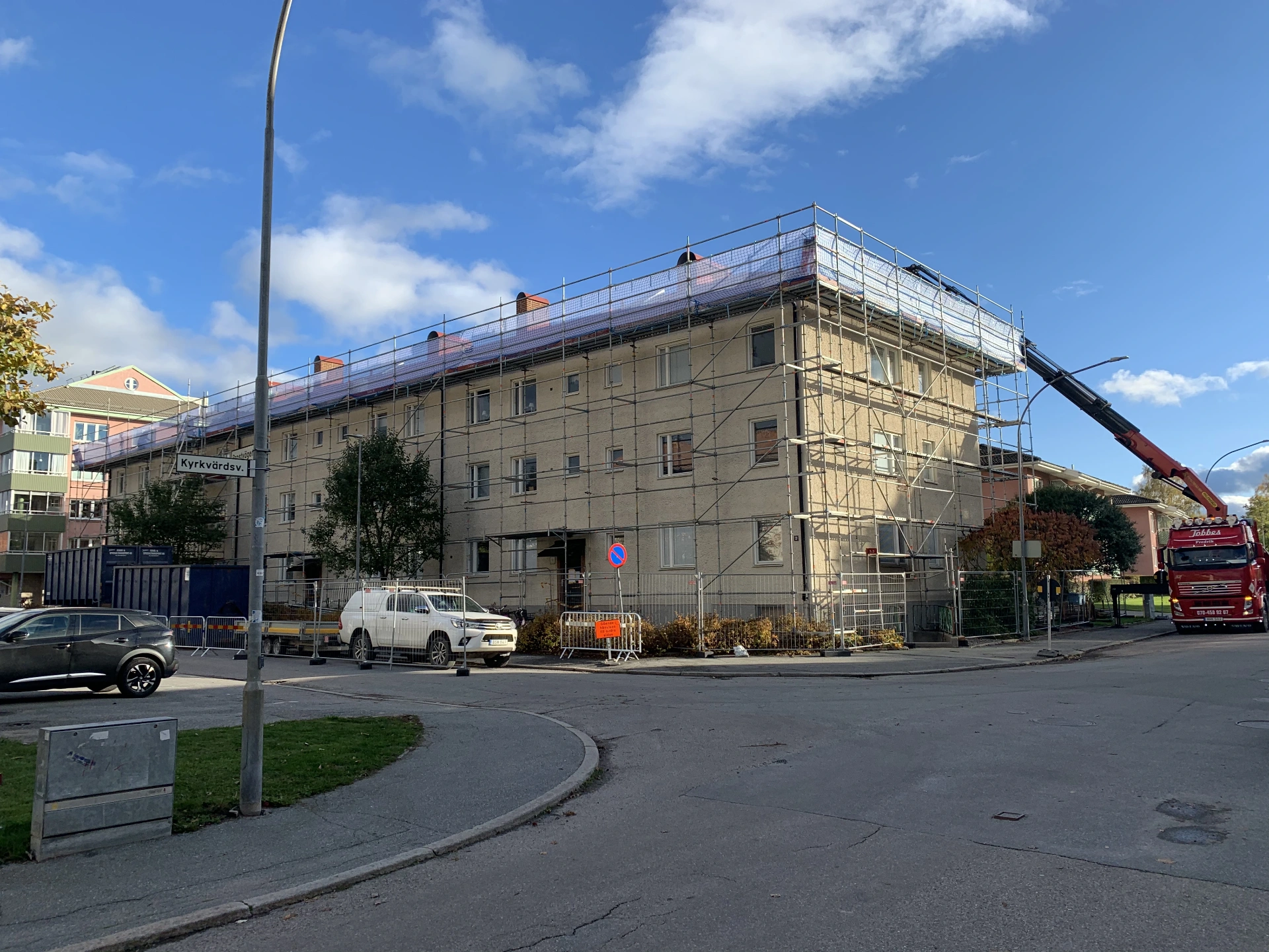 Flerbostadshus med byggställning under fasad- och takrenovering
