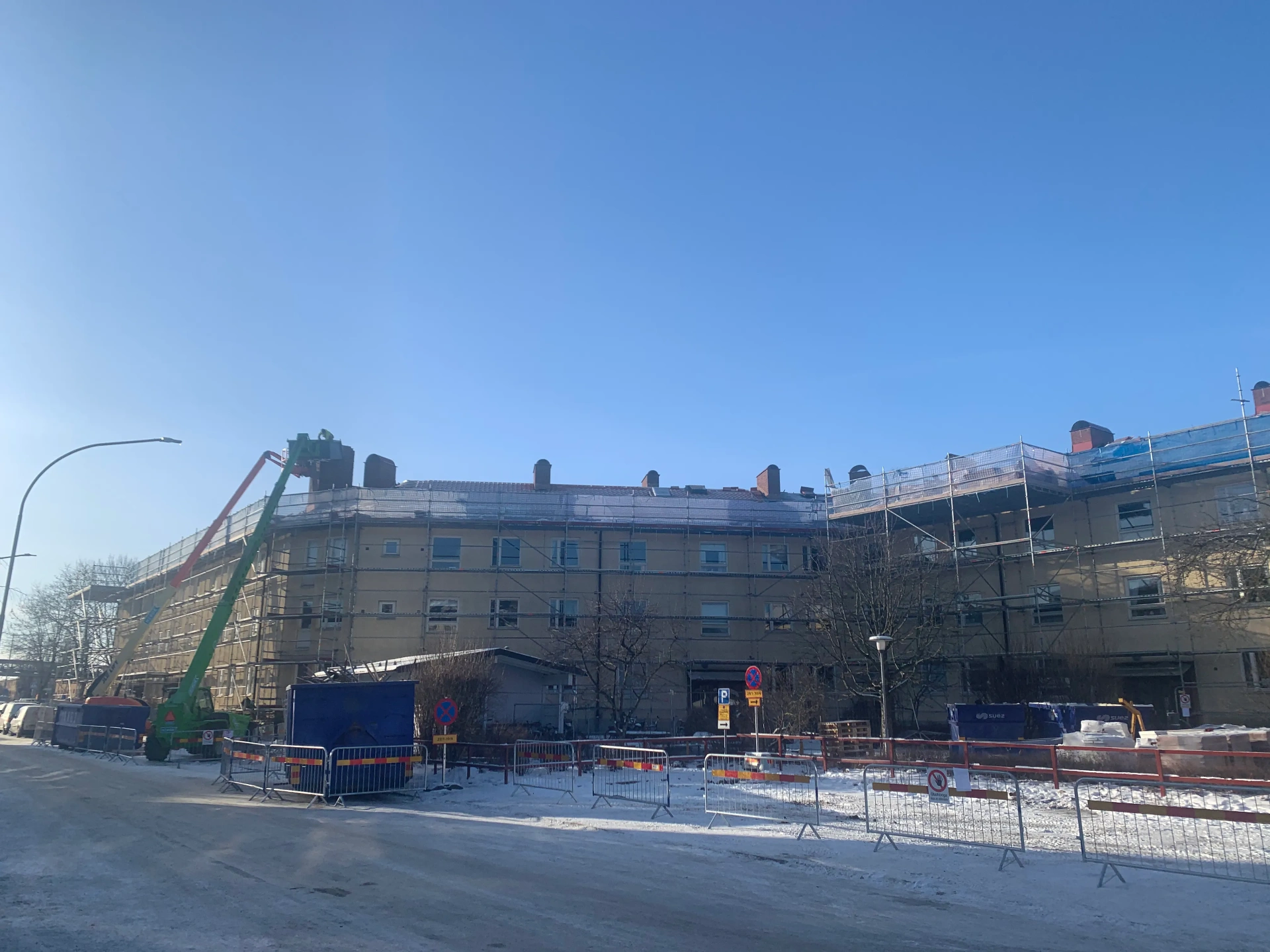 Renovering av flerbostadshus med byggarbetsplats framför