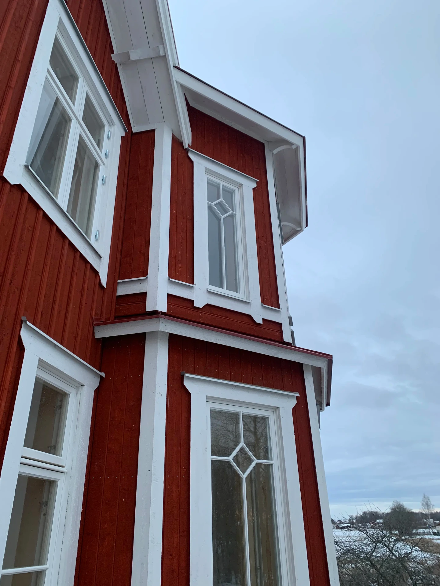 Rött trähus med vita snickerier och torn